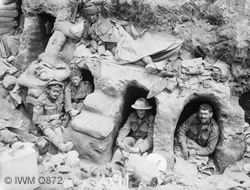 Men of the Border Regiment resting in shallow dugouts near Thiepval Wood during the Battle of the Somme during August 1916. (IWMQ872)